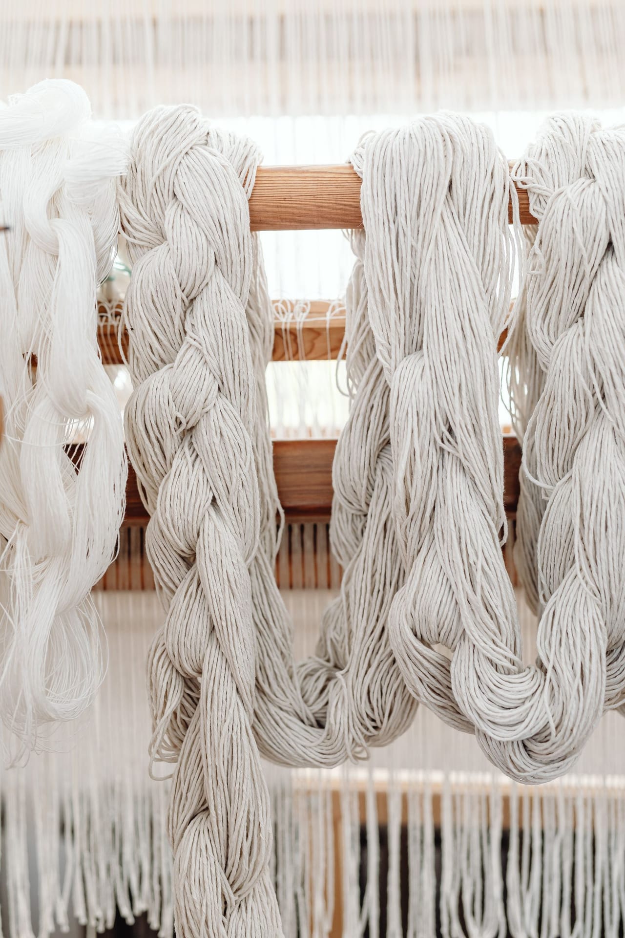 Warp threads interlaced with weft on a loom showing the plain weave over-under structure of cloth forming on the loom